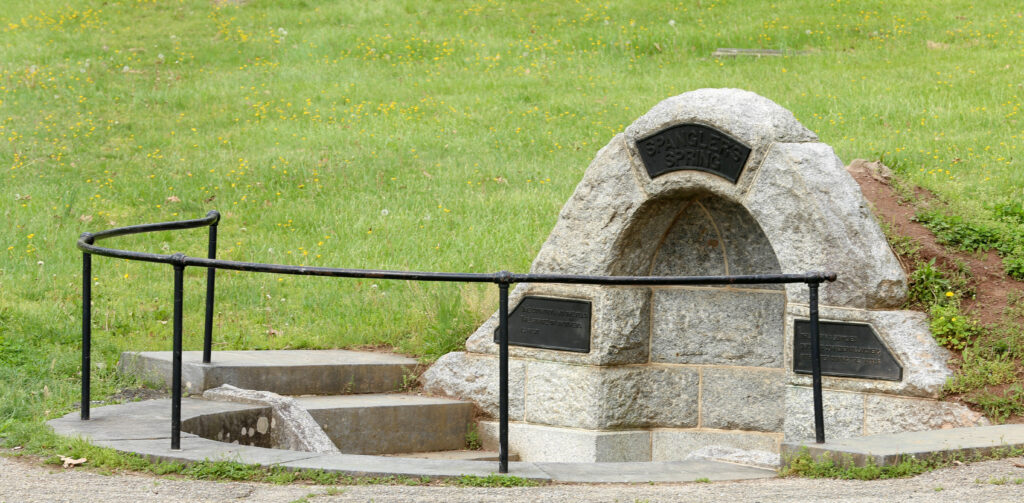Granite dome over Spangler's Spring with a bronze name plaque, iron railing and stone steps