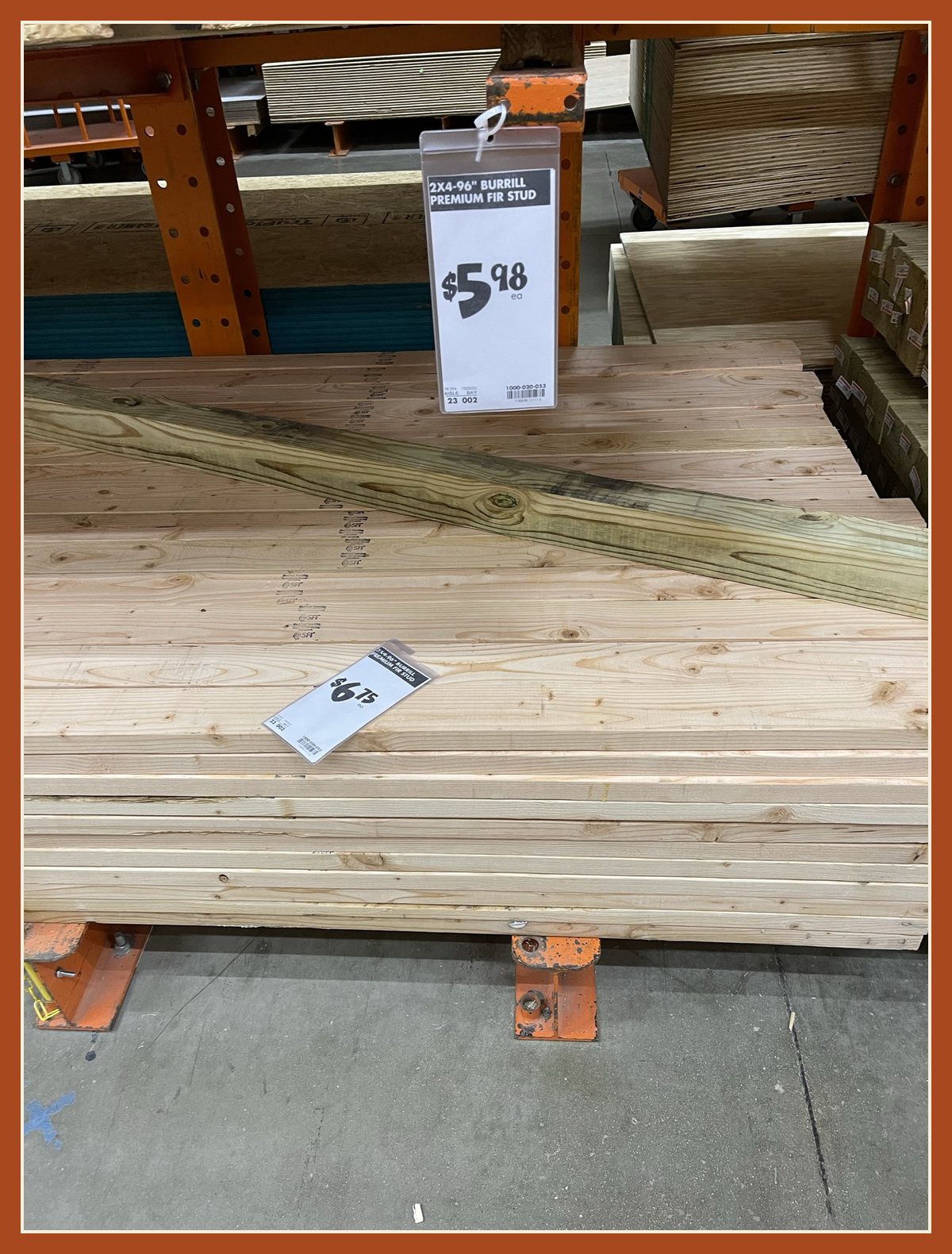 A stack of 2x4 studs at the lumber store under a price tag reading 2x4-96 inch Burrill Premium Fir Stud, $5.98 each.