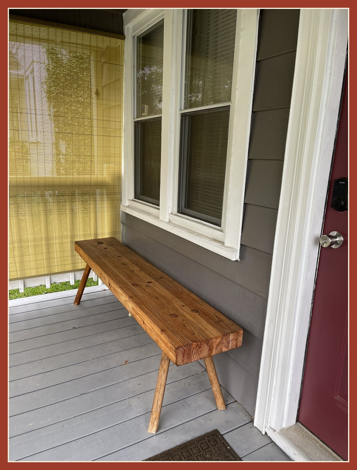 The low Roman workbench today, now a deep honey brown, sitting on the front porch of Adam's house.
