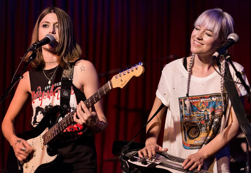 Larkin Poe's Rebecca and Megan Lovell on stage, one on guitar and one on lap steel