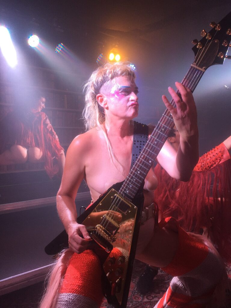 Peaches performing with a guitar