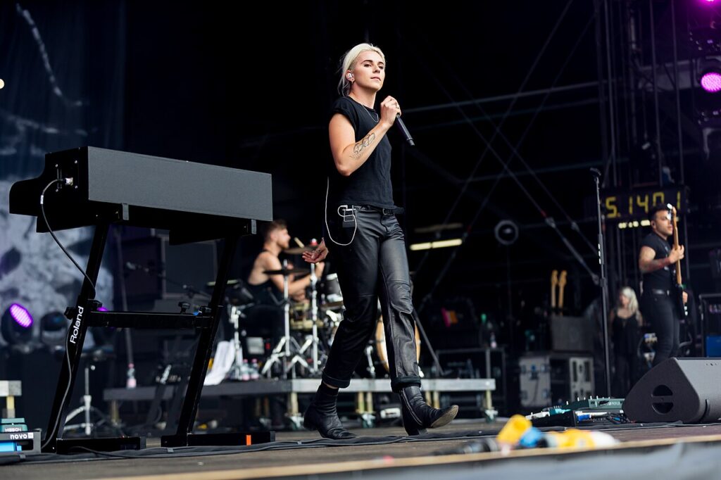 PVRIS performing on a festival stage, singer at the microphone