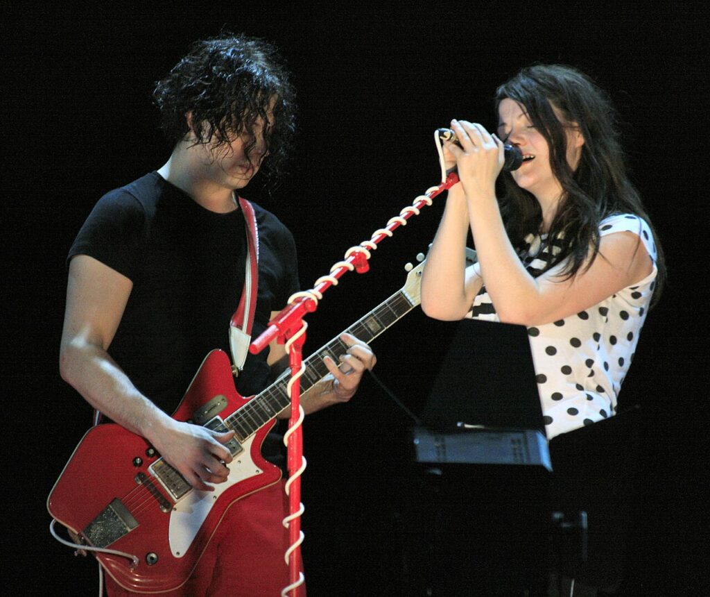 Jack and Meg White of The White Stripes on stage, Jack with a red guitar
